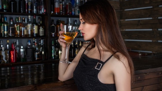 Picture of a lady having a drink at a bar