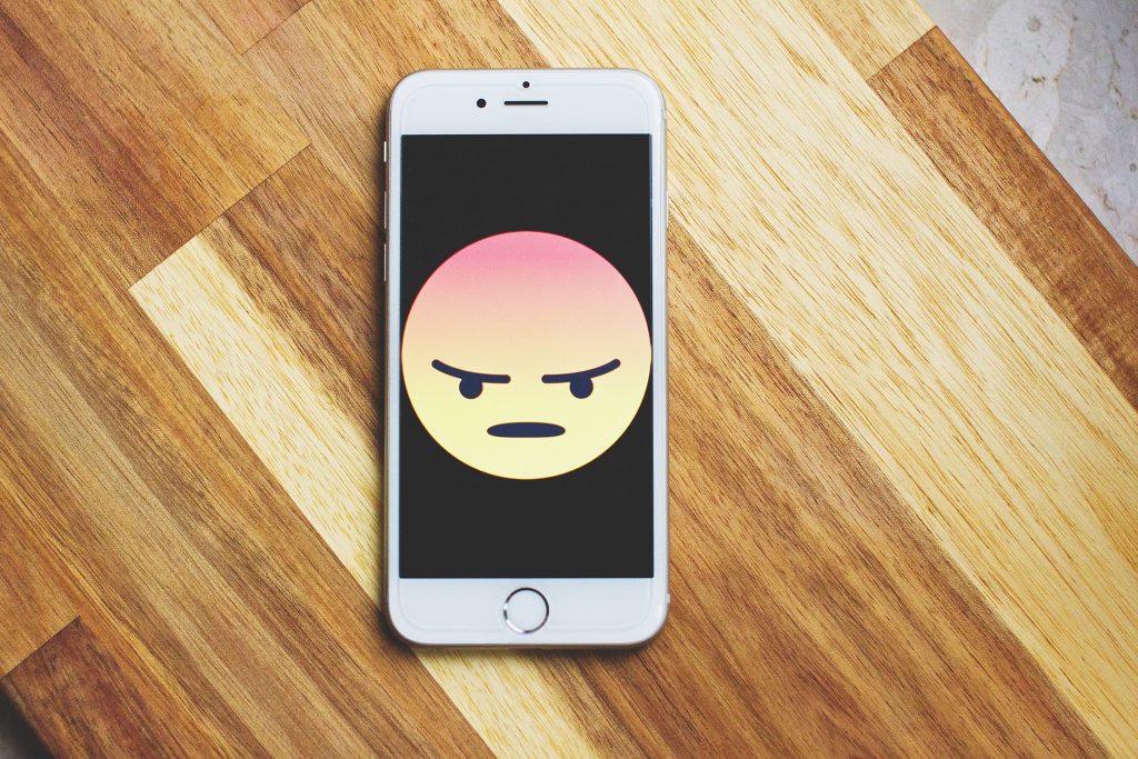 Phone with an angry emoji on