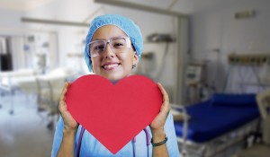 Nurse with a smile, holding a cut out paper love heart