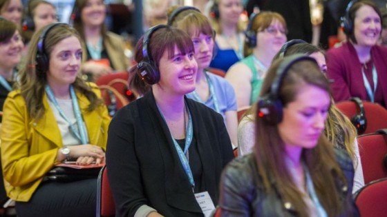 Woman in crowd looking pleased to be an the event