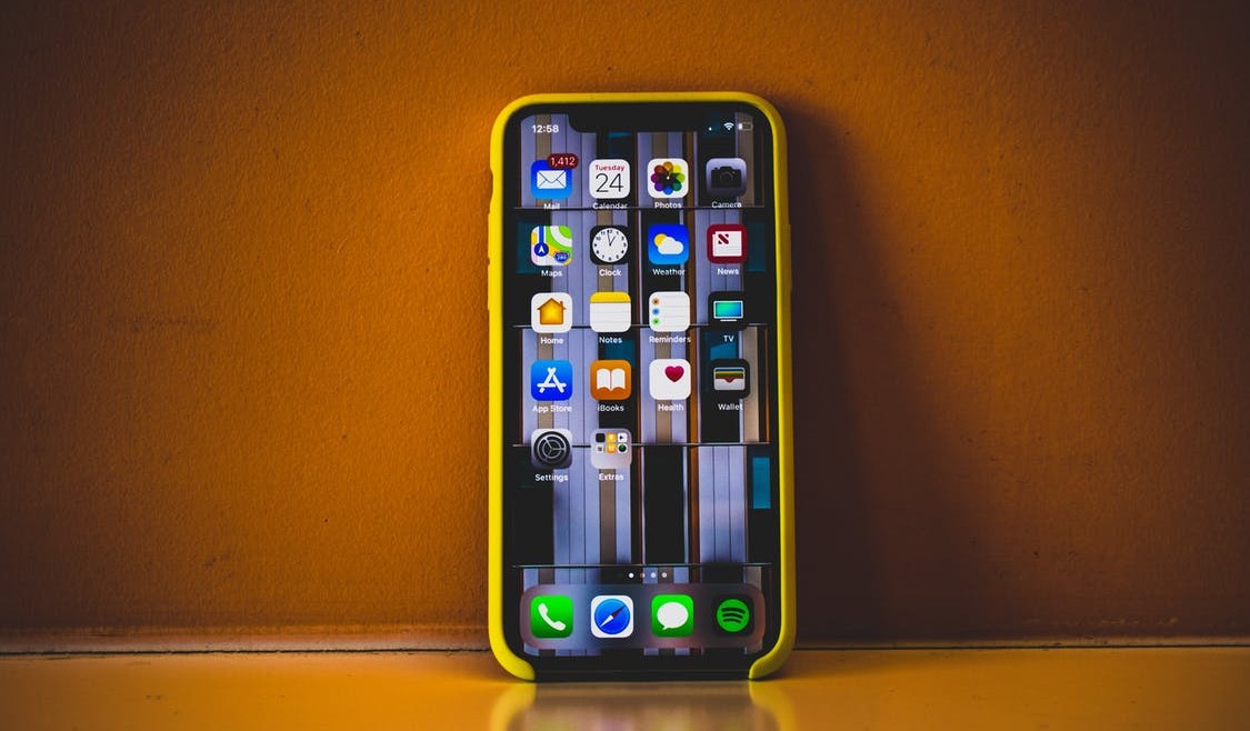 Iphone XR with apps - phone is yellow and orange sunburnt background