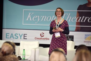 Woman stood up as a speaker in front of a masterclass of people