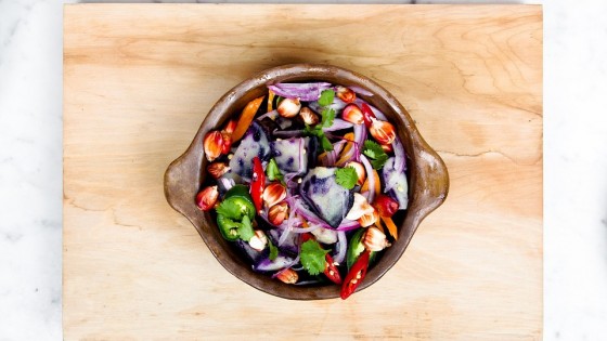 Vegan food in a bowl on a chopping board on a marble counter top